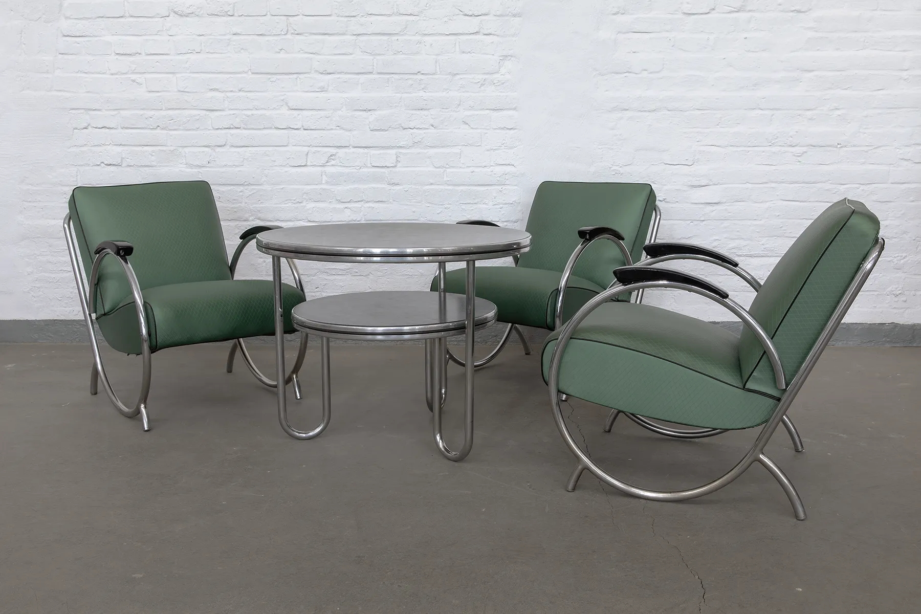 Tubular steel armchairs in the style of German Streamline Moderne, produced in the early 1950s in Nuremberg. Chrome frame, original green upholstery, and Bakelite armrests.