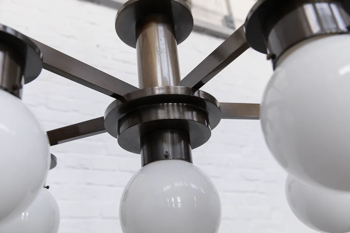 1930s modernist chandelier made of nickel-plated brass with three vertically arranged cylindrical shades in opalglas; a striking example of functional yet decorative German lighting design.