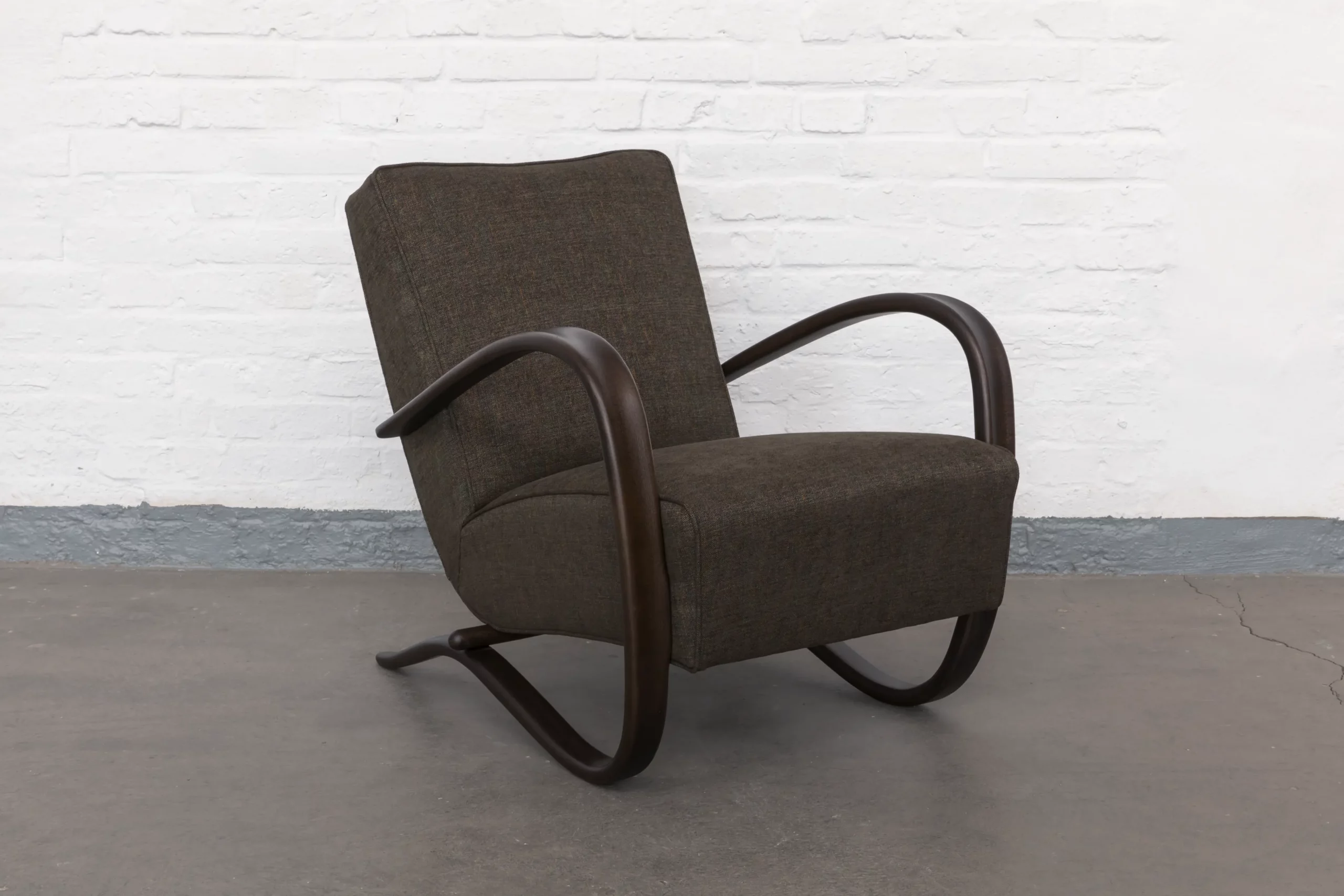 Streamline armchair H269 by Jindřich Halabala, made in 1930s Brno, bentwood armrests and traditional horsehair upholstery. Restored with great attention to detail and upholstered in a subtly melanged brown fabric, this design reflects the elegance and innovation of Czechoslovak modernism.