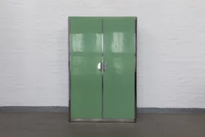 Front view of a 1930s reseda-green wardrobe by Rudolf Vichr with chromed steel frame and sculptural avant-garde door handles, photographed closed against a white brick wall.