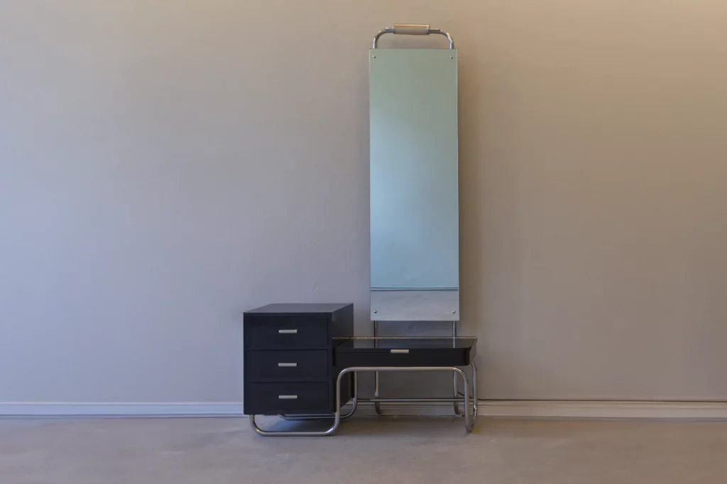 Mirror cabinet in Bauhaus style with chromed tubular steel frame, black drawer unit, integrated lighting and tall mirror panel.