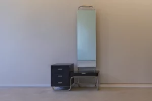 Mirror cabinet in Bauhaus style with chromed tubular steel frame, black drawer unit, integrated lighting and tall mirror panel.
