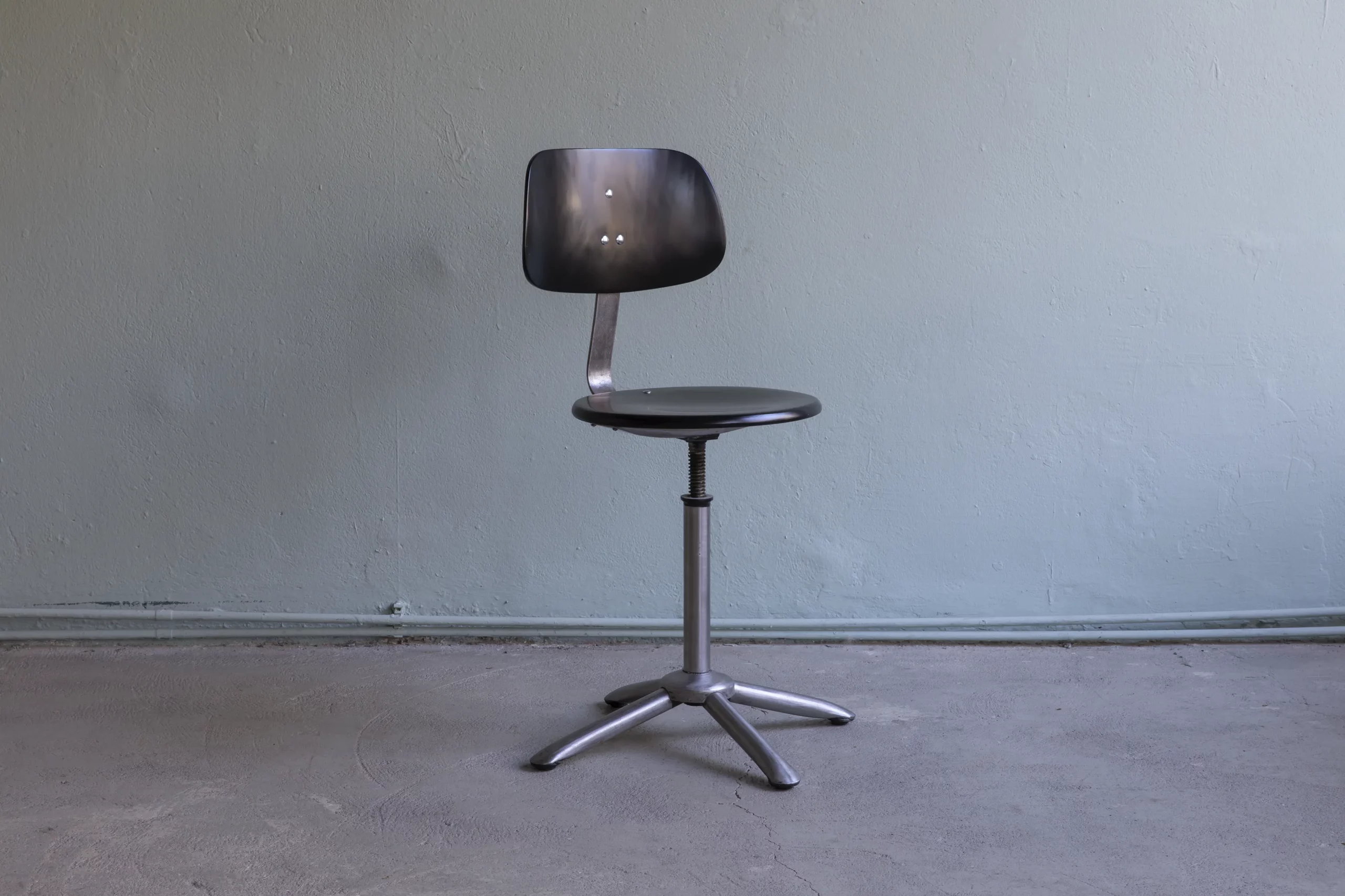 Original 1950s Mid Century swivel chair with height-adjustable metal base and black lacquered beechwood seat and backrest.