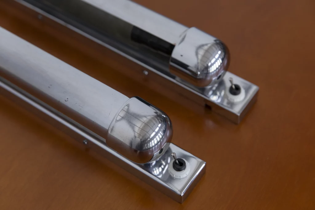 Chromed Bauhaus wall lights in zeppelin form from the 1930s with rotatable reflector shades and minimalist toggle switches.