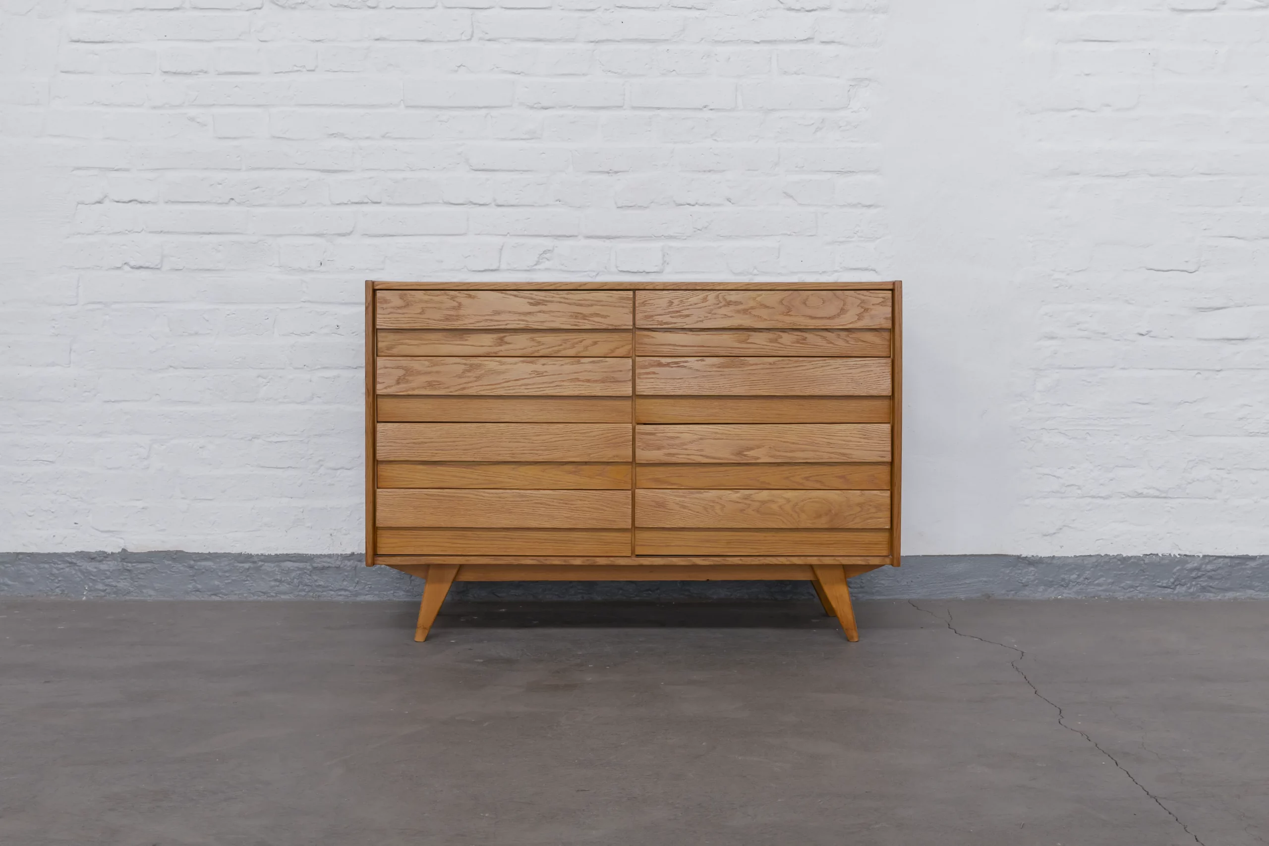Restored U453 sideboard by Jiří Jiroutek for Interiér Praha in lacquered and polished oak. Czech Mid-Century design from the 1960s featuring ten drawers and a finely structured front.