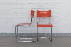 Original pair of Mart Stam B43 cantilever chairs from the 1930s with a chromed tubular steel frame and warm orange lacquered plywood seat and backrest.