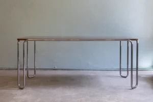 Bauhaus tubular steel loop-leg table with a chromed tubular steel frame and a tabletop in book-matched walnut veneer.